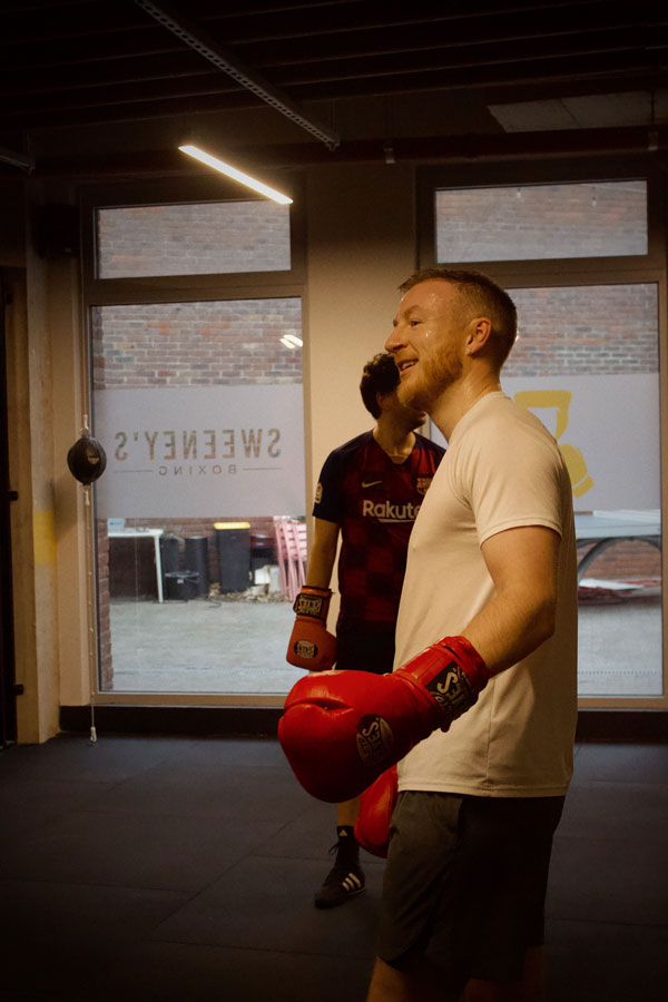 Man boxing punching bag at gym